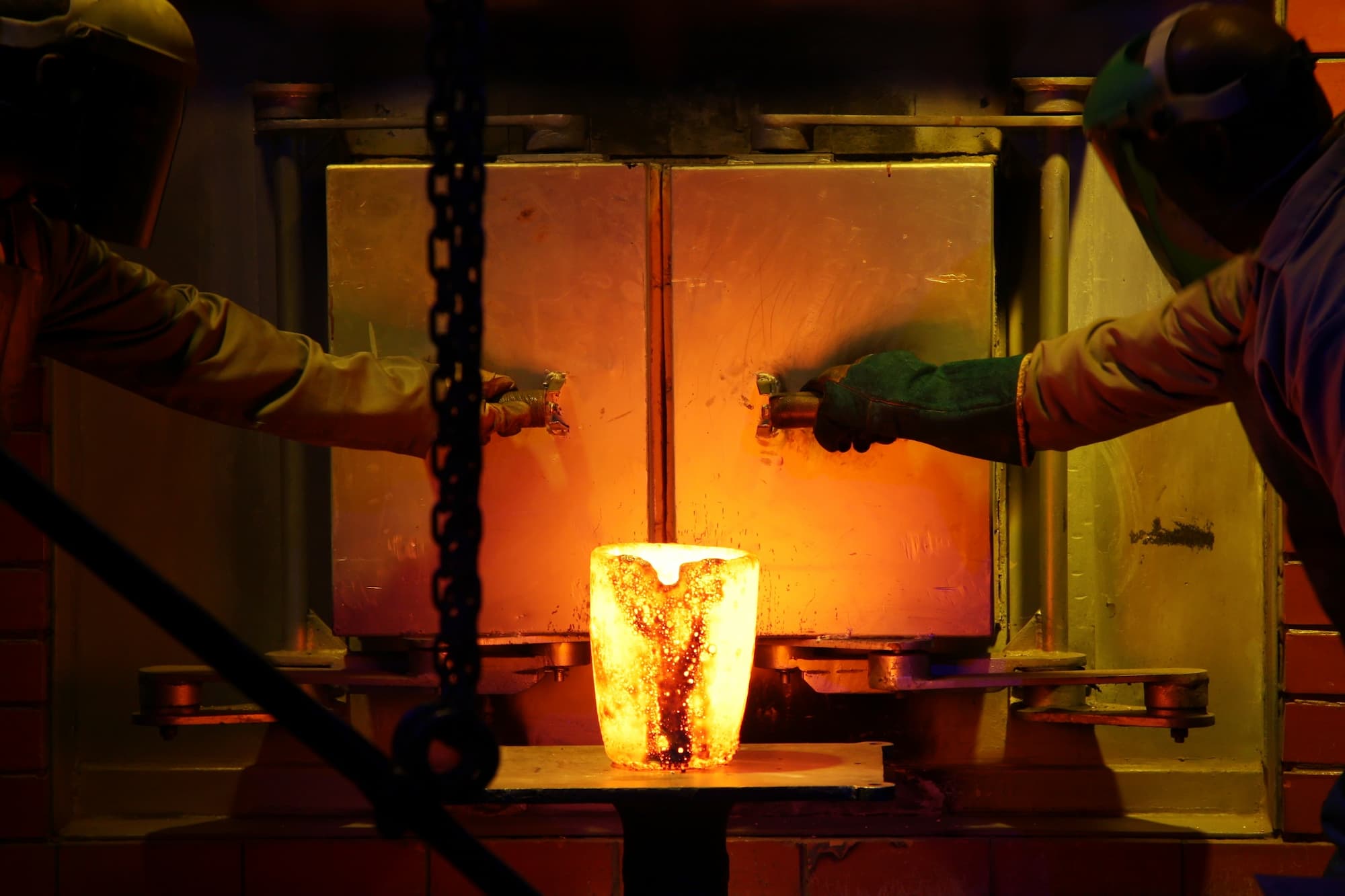 Centrifugal casting workers refining metal. 