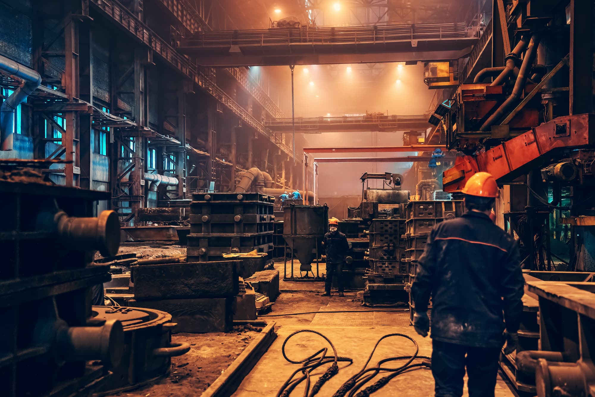 Engineers working in a large metal manufacturing workshop.